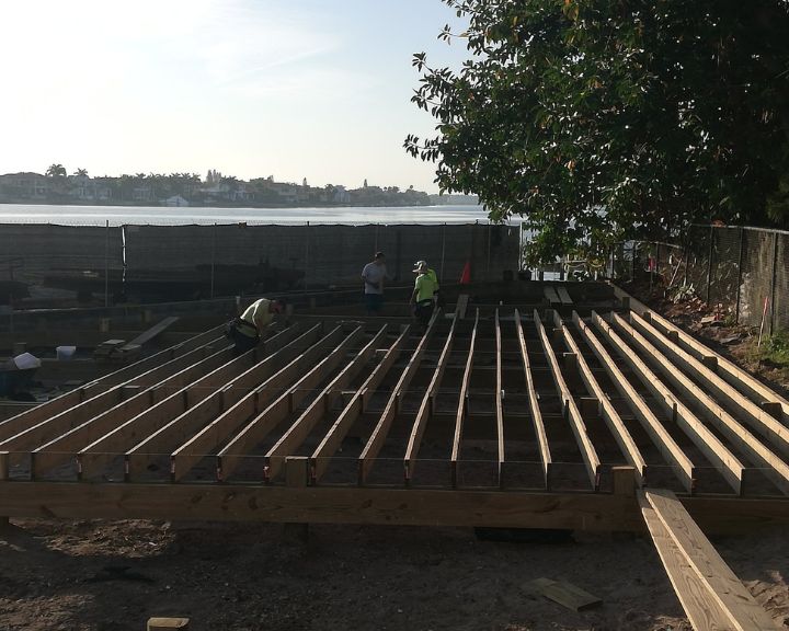 A group of workers are working on a wooden deck.
