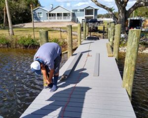 A dock builder in Orlando carrying out repairs on a boat dock.