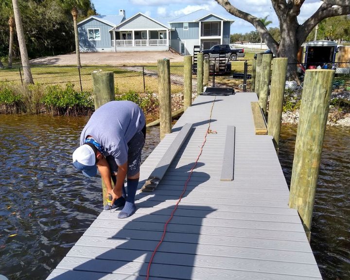 A dock builder in Orlando carrying out maintenance on a boat dock.