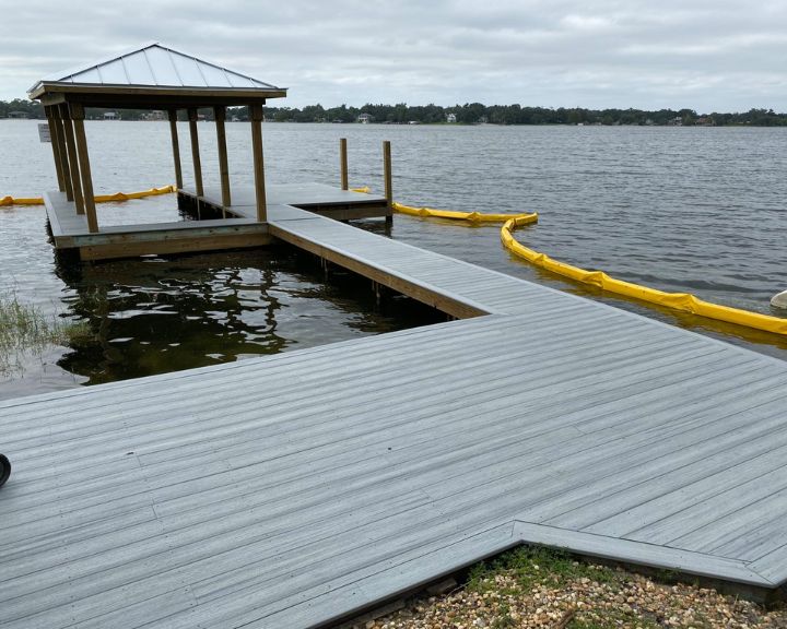 A new boat dock construction in Orlando featuring grey composite decking and a pergola.