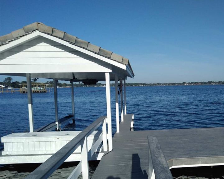 A dock with a white gazebo on the water.