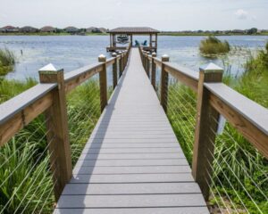 A wooden boardwalk leading to a newly installed boat dock on a lake in Orlando.