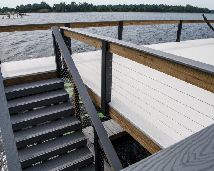 Orlando Dock Builders constructed a wooden deck with stairs leading to a body of water.