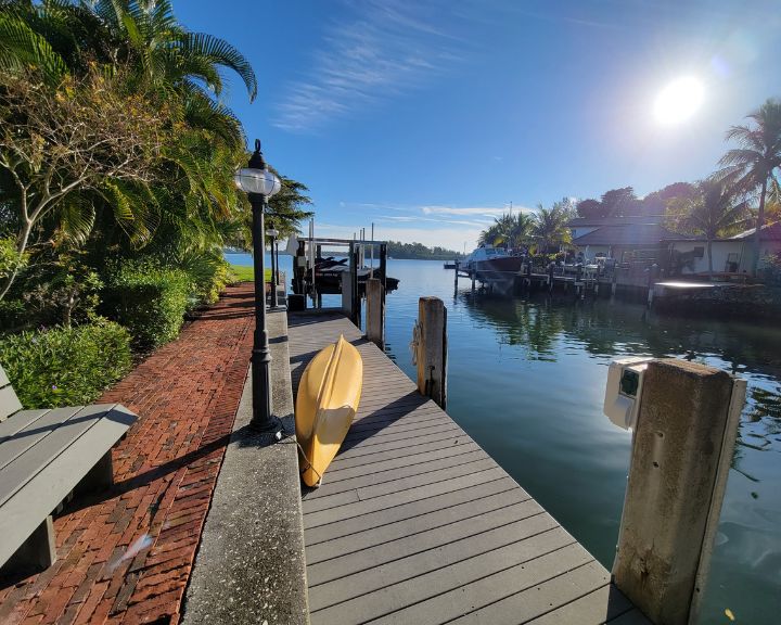 Orlando Dock Builders created a stunning dock adorned with palm trees where a vibrant kayak rests.