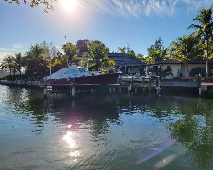 Orlando Dock Builders constructed a boat docked in the water next to a house.