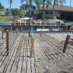 A concrete foundation is being built in a yard.